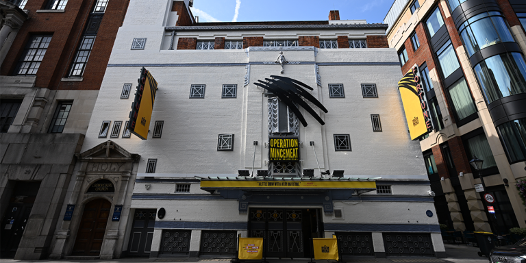 The Fortune Theatre exterior features red brick, with a clear blue sky in the background.