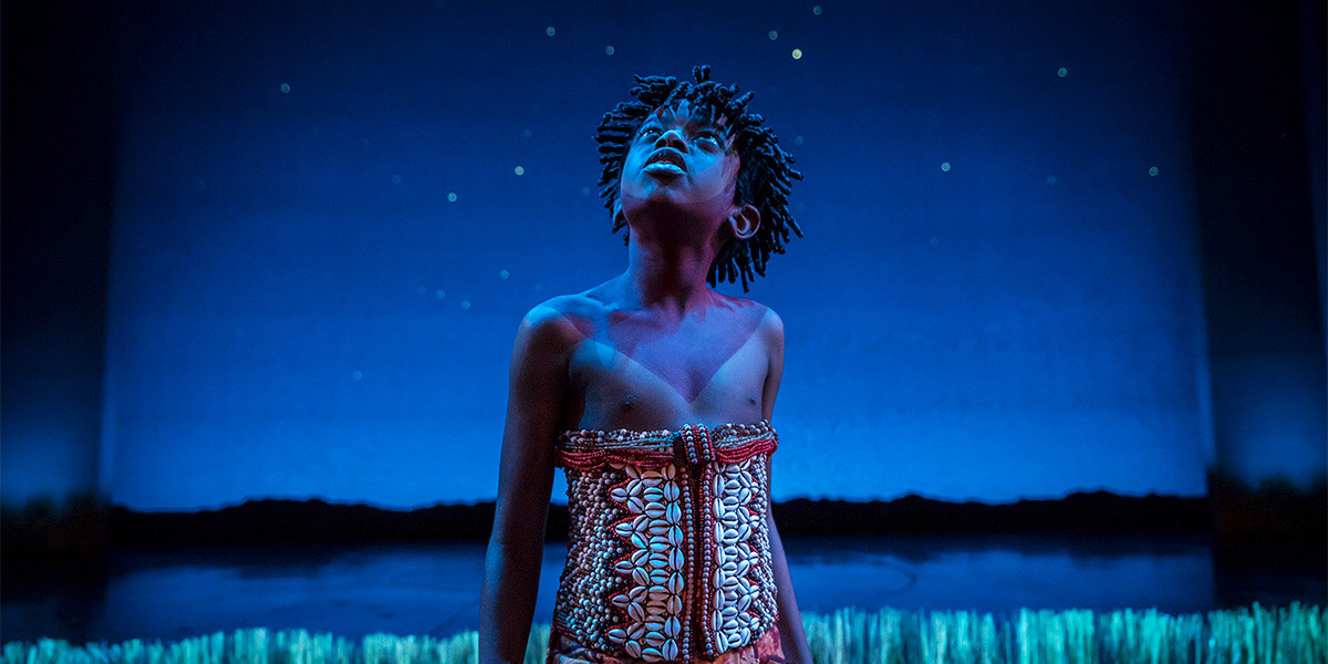 Young Simba stands proudly on a rock, bathed in golden light, with a vibrant savannah backdrop.