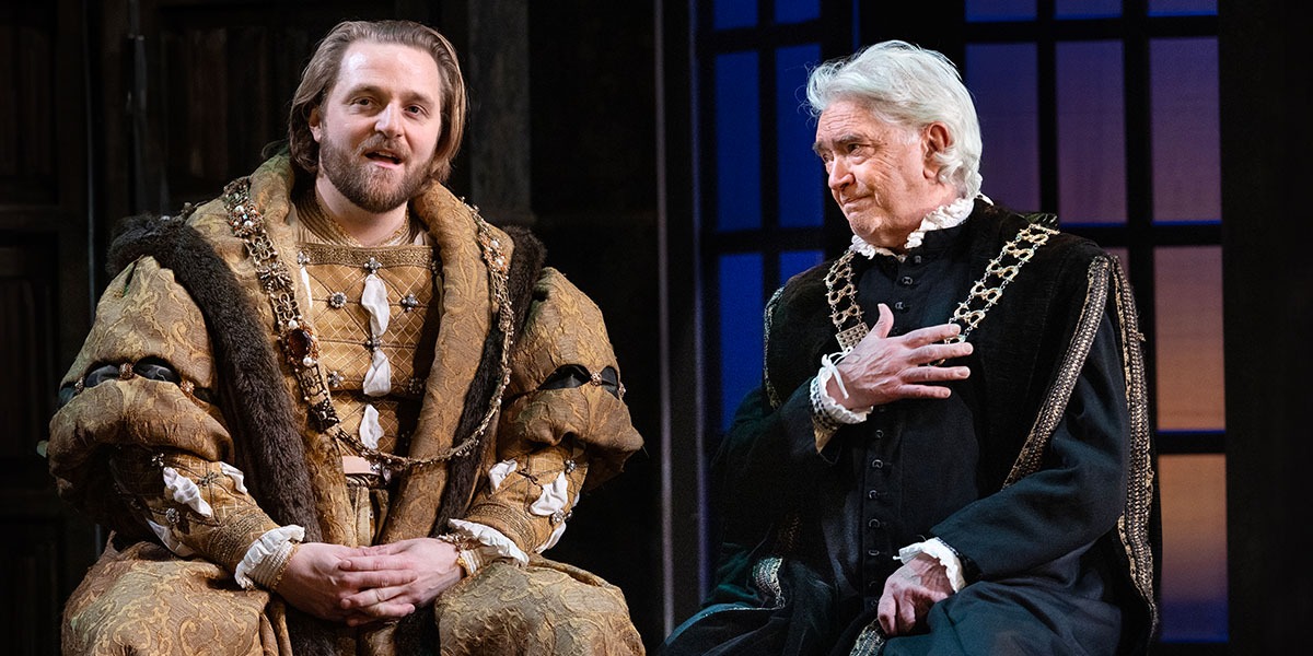 Orlando James and Martin Shaw are sat down talking in Tudor dress