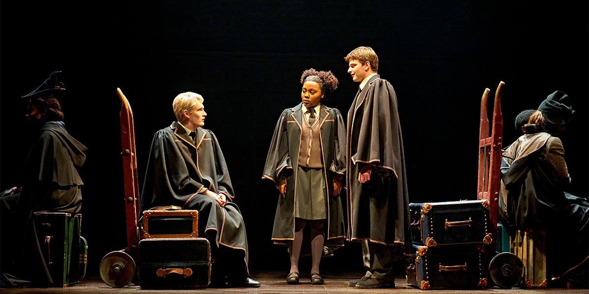 Scorpius Malfoy, Rose Granger-Weasley, Albus Potter, and Alexandra Sullivan pose together, smiling against a dark background.