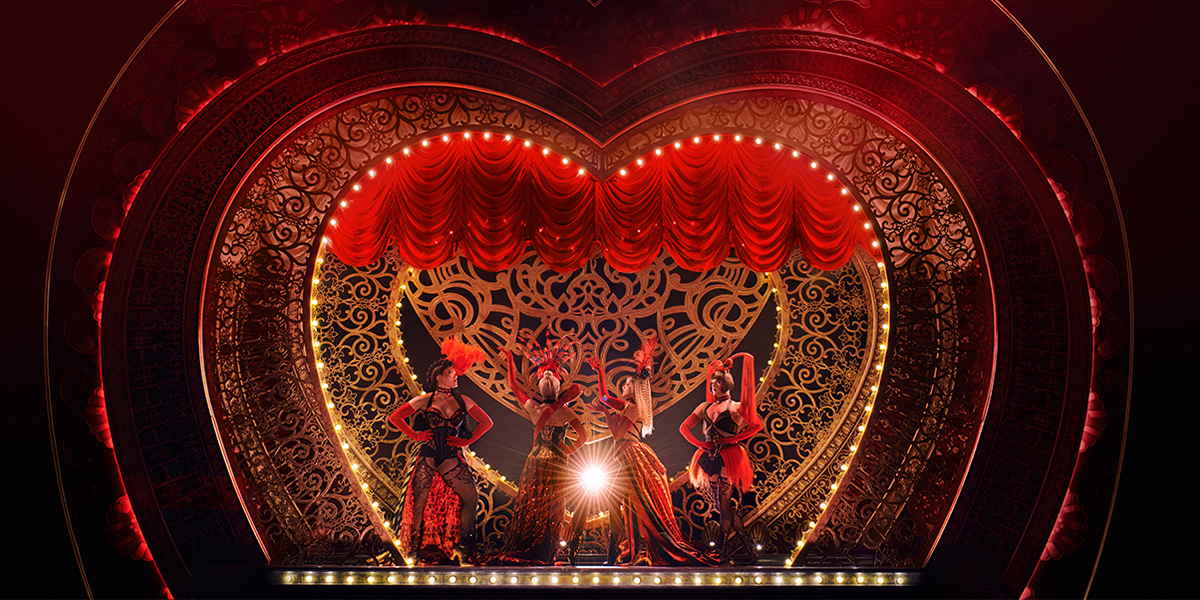 A vibrant stage scene from Moulin Rouge! The Musical, featuring performers in elaborate costumes and dramatic lighting.