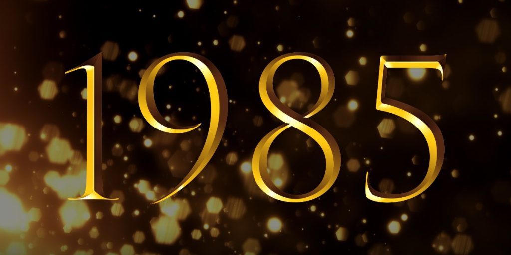 Golden numbers "1985" on a dark background with shimmering golden particles, celebrating the Olivier Winners.