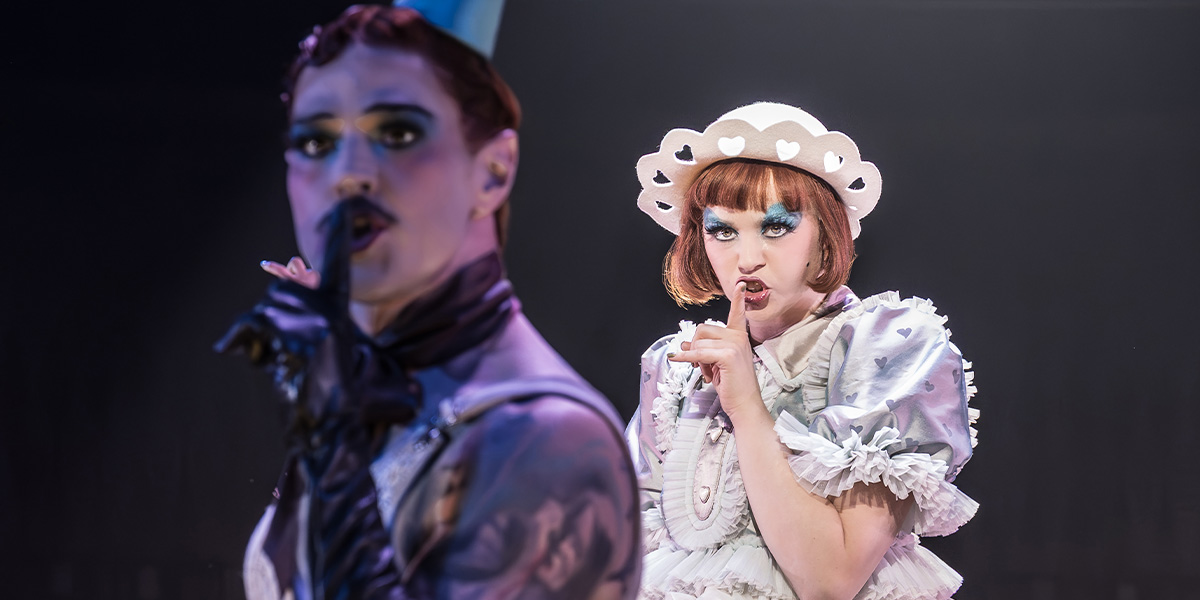 Matt Willis as Emcee and Katie Hall as Sally Bowles, both in theatrical costumes, shushing the audience.