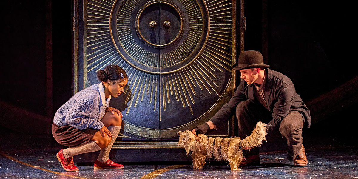 Two people stand beside the wardrobe with a cat.