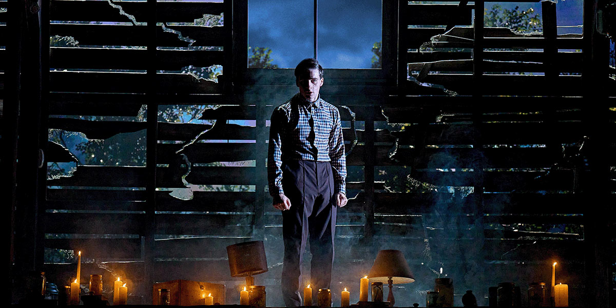 Louis Healy and Henry Creel stand together, both in dark clothing, against a dimly lit background.
