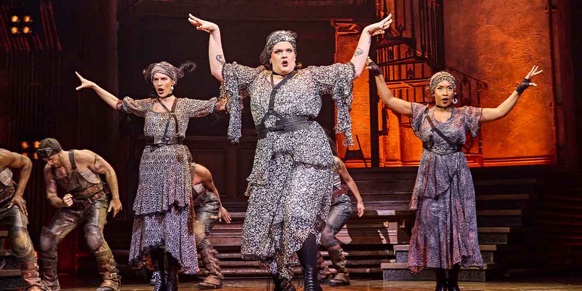 Melanie Bright, Spike Maxwell, and Lauran Rae perform in Hadestown, wearing vibrant costumes on a theatrical stage.