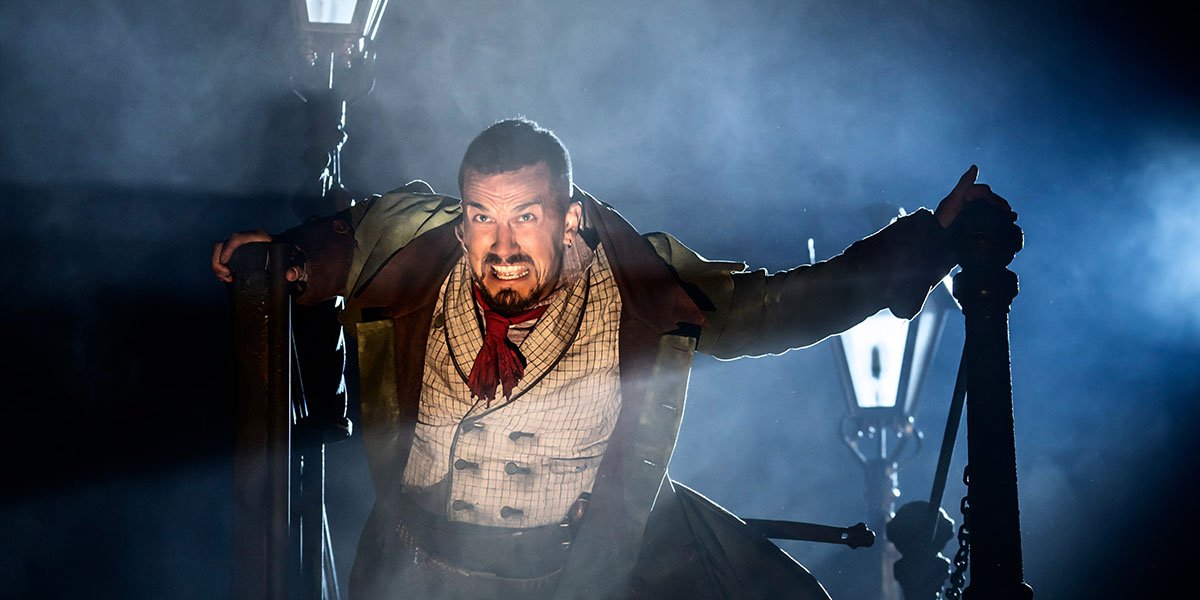 Oliver Aaron Sidwell, dressed as Bill Sikes, poses menacingly in a dark, textured costume.