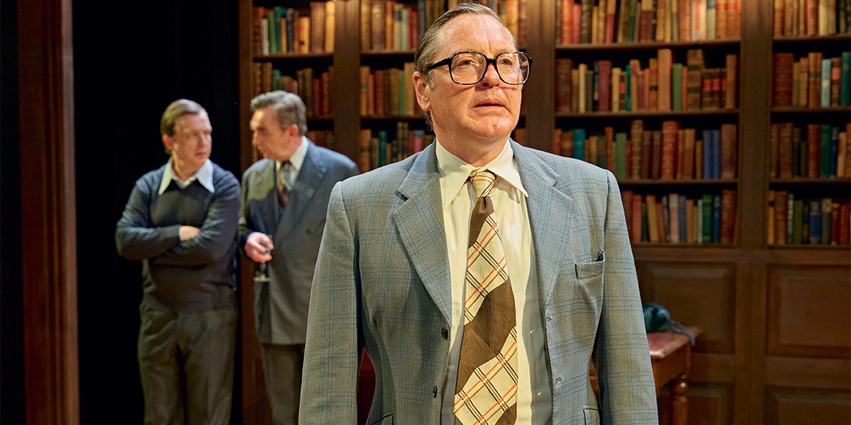 Alan Cox (Tony Crosland) Hywel Morgan (Roy Jenkins ) and Colin Tierney (Denis Healey) are sitting in an office. In the background a large, full bookcase can be seen.