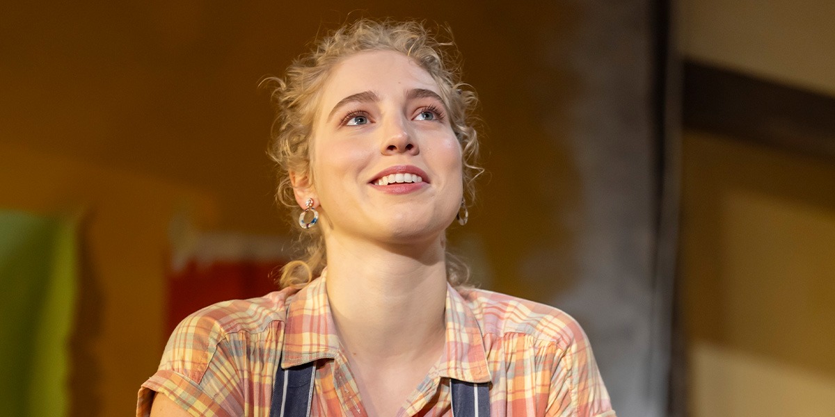 Tessa Bonham Jones (Hallie) is looking upwards and smiling.
