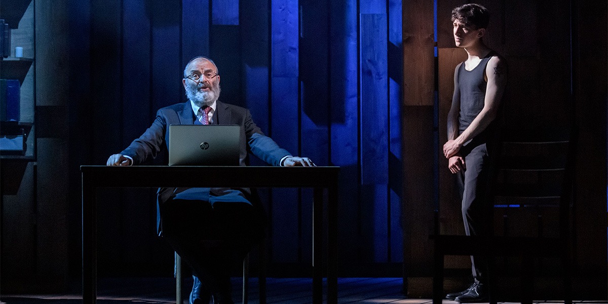 On the left a person sits at a desk with a laptop in front of them. On the right a person is standing with their arms crossed in front of them.