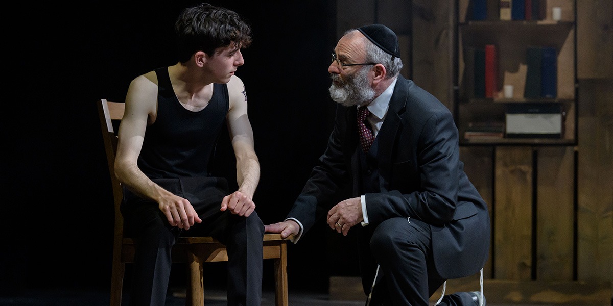 Two people are sitting together. The person on the right appears to be advising the person on the right.