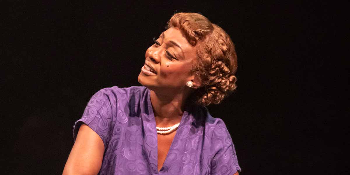 Beverley Knight as Sister Rosetta Tharpe, wearing a purple dress, smiling against a dark background.
