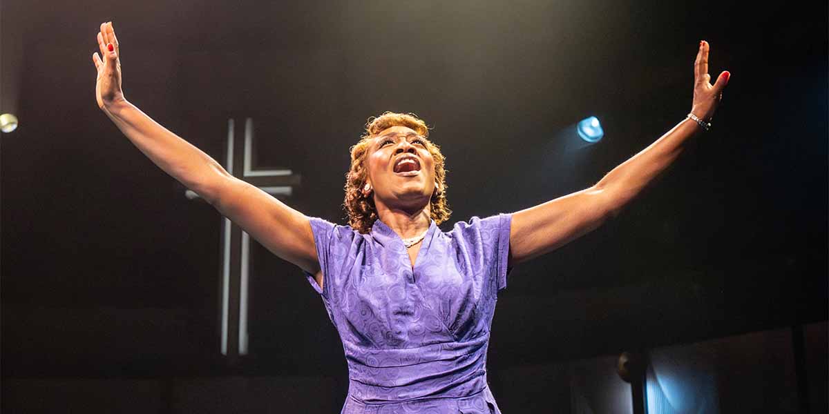 Beverley Knight, as Sister Rosetta Tharpe, performs passionately with arms raised, wearing a purple dress.