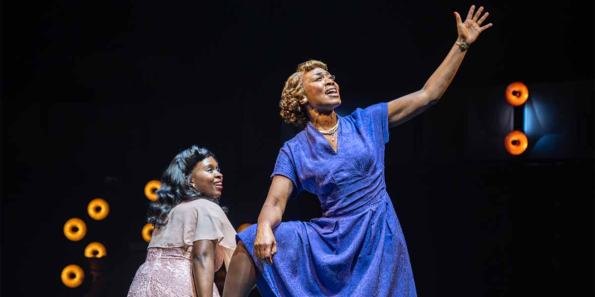 Ntombizodwa Ndlovu and Beverley Knight perform on stage, with dramatic lighting and vibrant costumes.