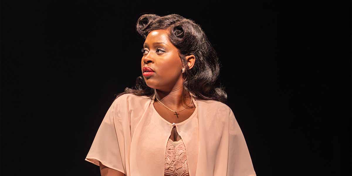 Ntombizodwa Ndlovu as Marie Knight, wearing a light pink outfit, gazes thoughtfully against a dark background.