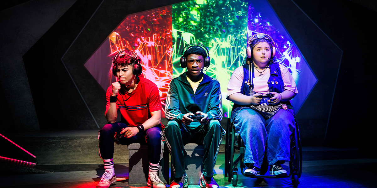 Three individuals playing video games with colorful, dynamic digital graphics in the background. They are seated in a dimly lit room, each holding a game controller and focused intently on their gameplay.
