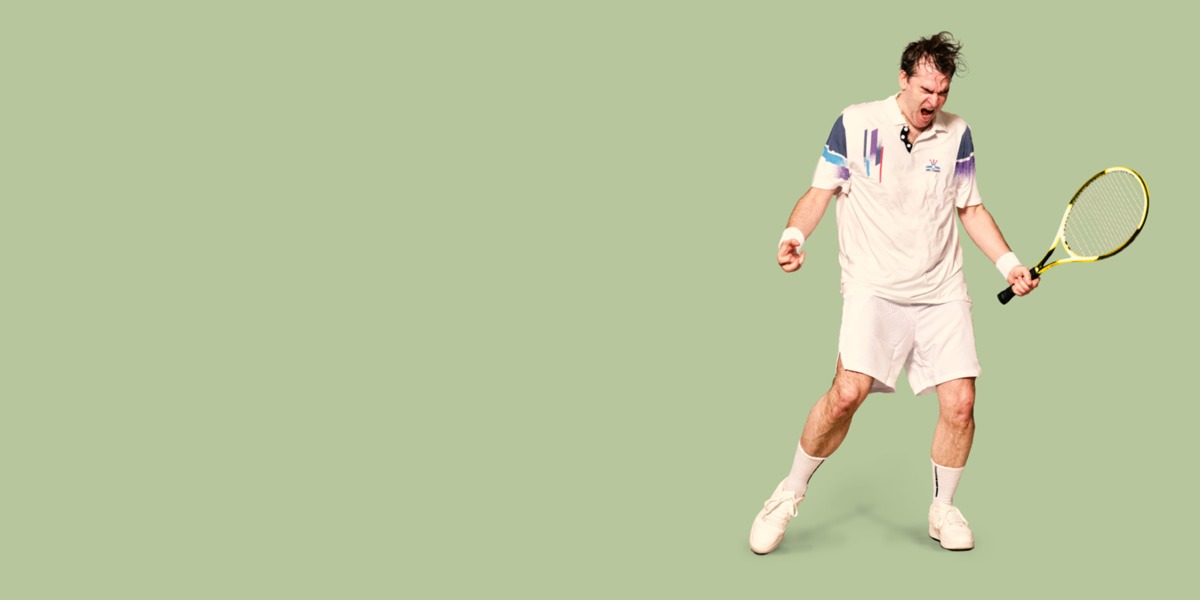 There is a Pistachio green background. To the right of the image is a man where tennis whites (t-shirt and shorts and trainers). There is some blue and purple stripes on the sleeves and the left shoulder. He is sweaty and his hair is dishevelled. He is holding a yellow and black tennis racket in his right hand. His left hand is nearly balled in a fist. His mouth is open and eyes closed.