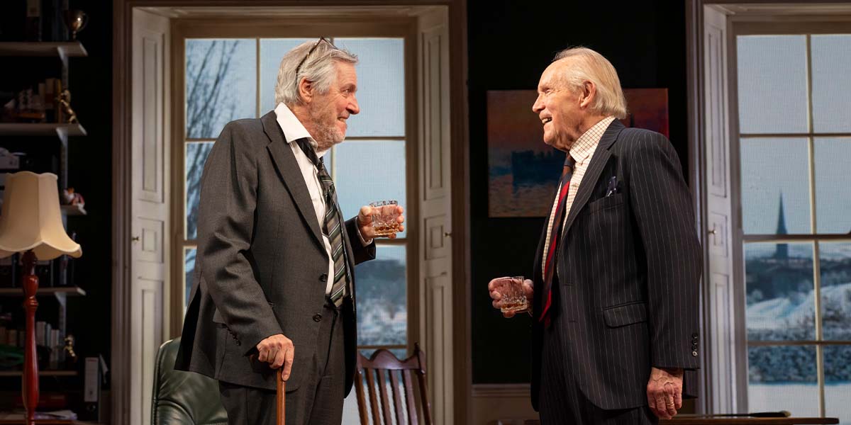 A woman with short hair stands at a podium, addressing an audience with a serious expression.