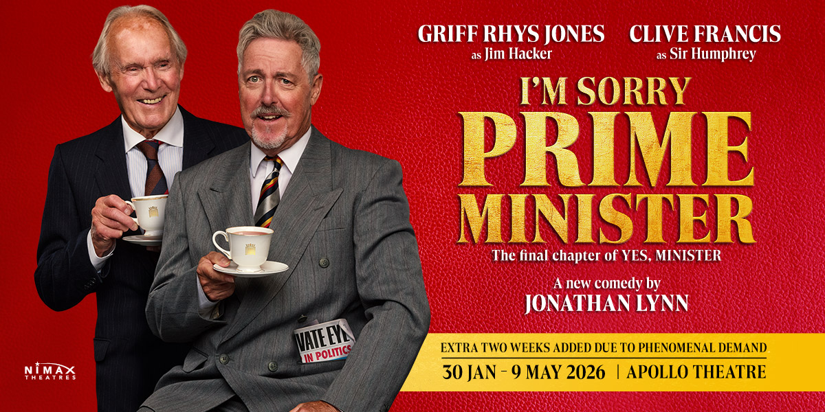 A protester holds a sign reading "I'm Sorry Prime Minister" against a backdrop of a crowd and buildings.