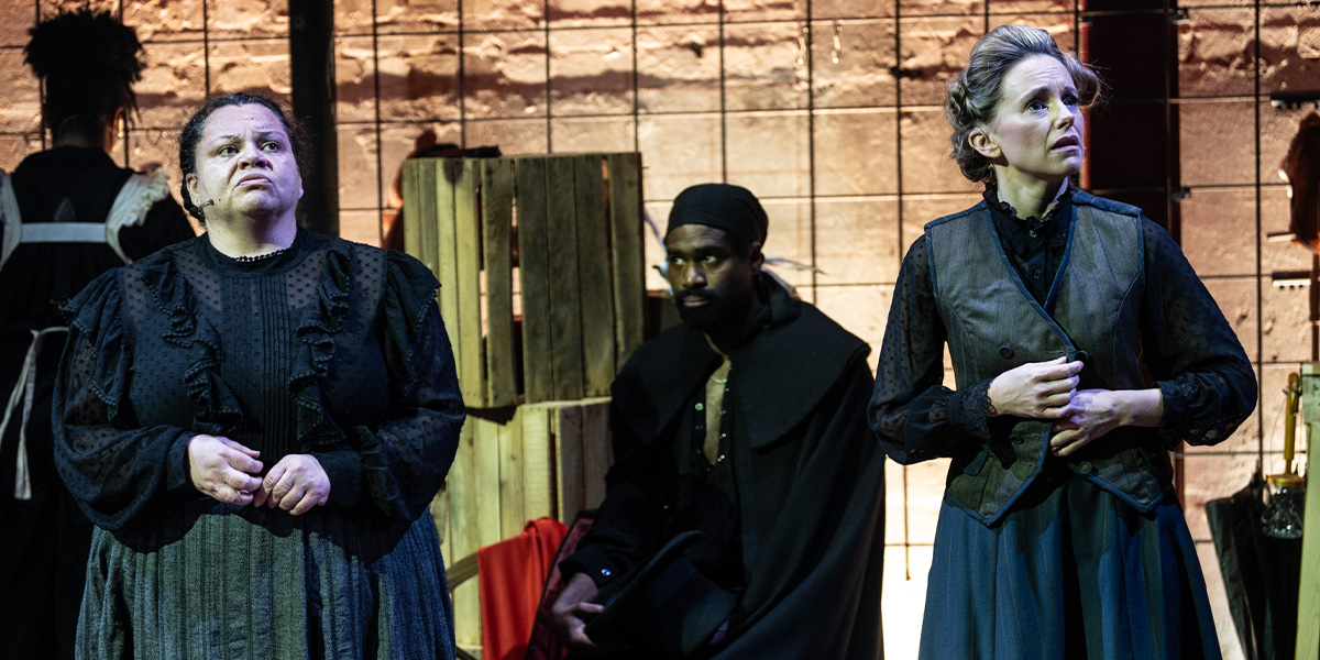 A group of people stand on stage bathed in light.