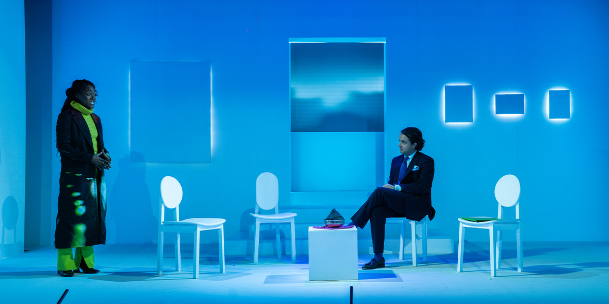 Arsema Thomas and Keelan Kember sit together, smiling, against a soft grey background.