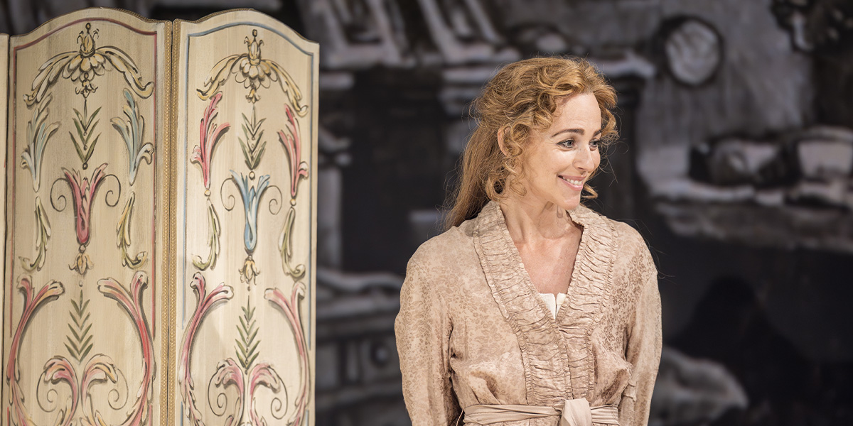 A woman in a flowing white dress poses gracefully, surrounded by soft, natural light and greenery.