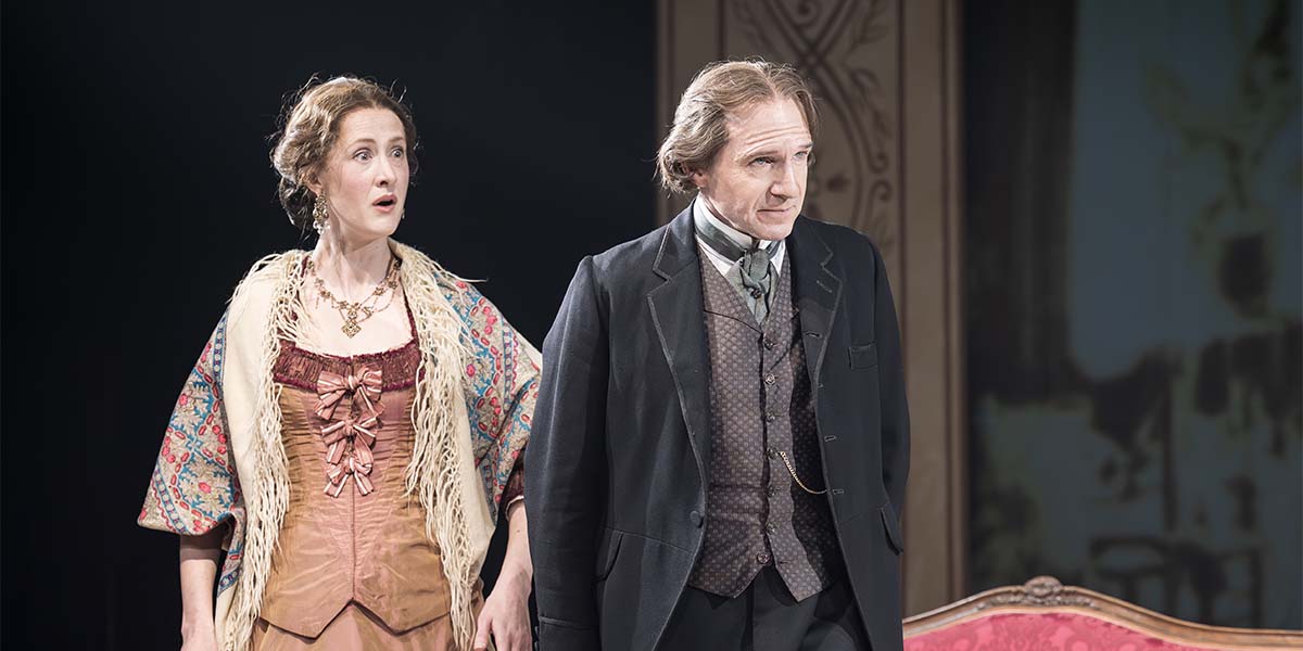 Kathryn Wilder as Kate Terry and Ralph Fiennes as Henry Irving, both in period costumes, on stage.
