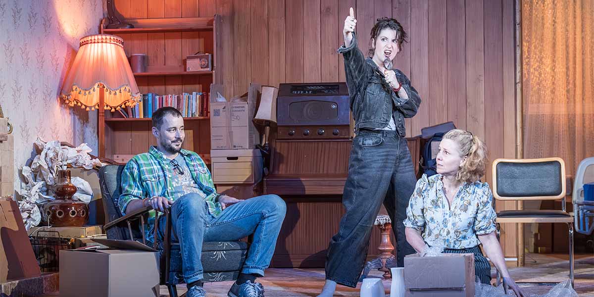 Sam Swainsbury, Charly Clive, and Sally Phillips pose together, smiling, in a brightly lit setting.