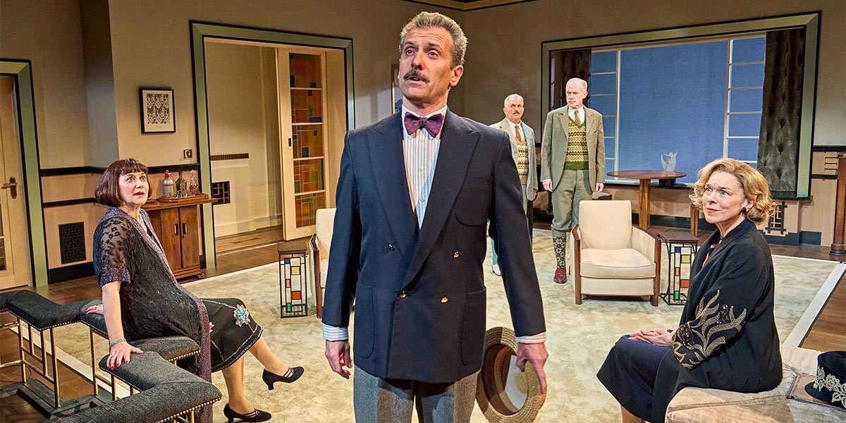 A dramatic stage scene from "The Company of Fallen Angels," featuring actors in elaborate costumes and lighting.