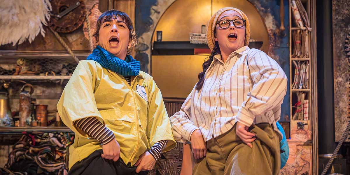 A dramatic scene from "The Tempest," featuring characters in elaborate costumes against a dark, stormy backdrop.