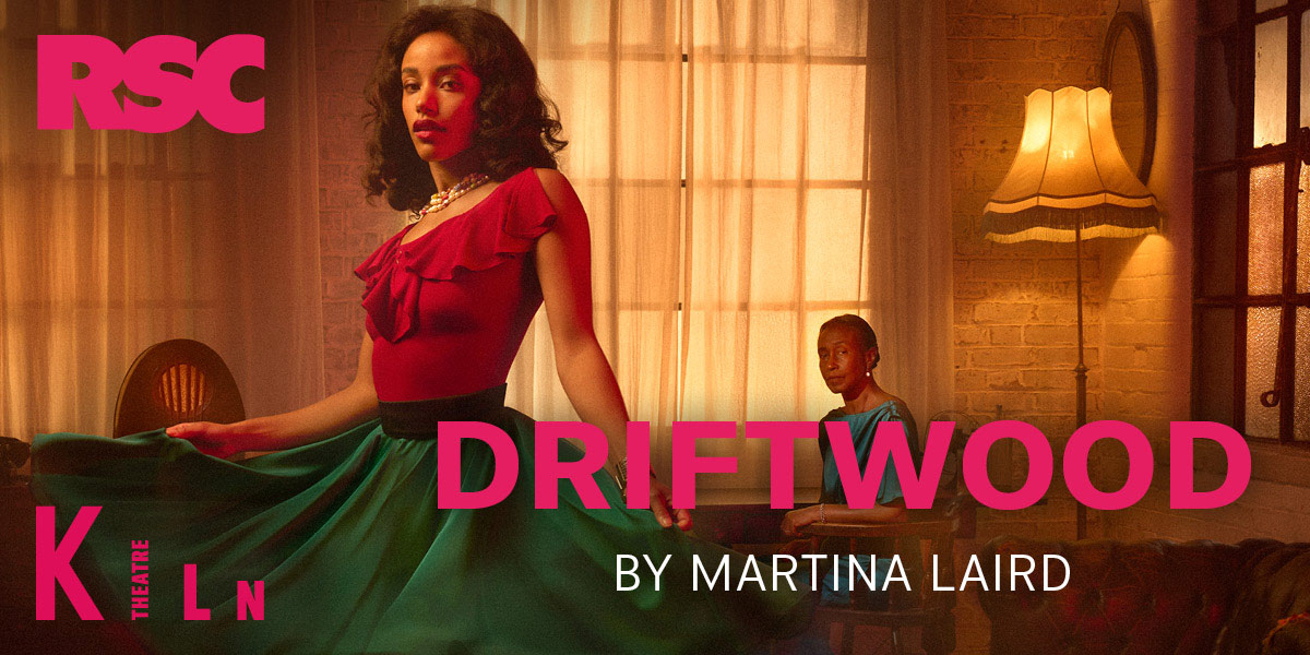 A piece of driftwood with textured bark and weathered surface, resting on sandy beach with gentle waves.