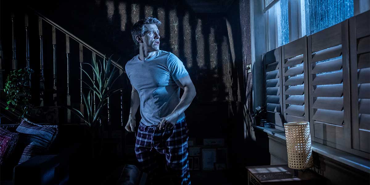 A dark, eerie scene featuring a ghostly figure in a dimly lit room, surrounded by shadows.