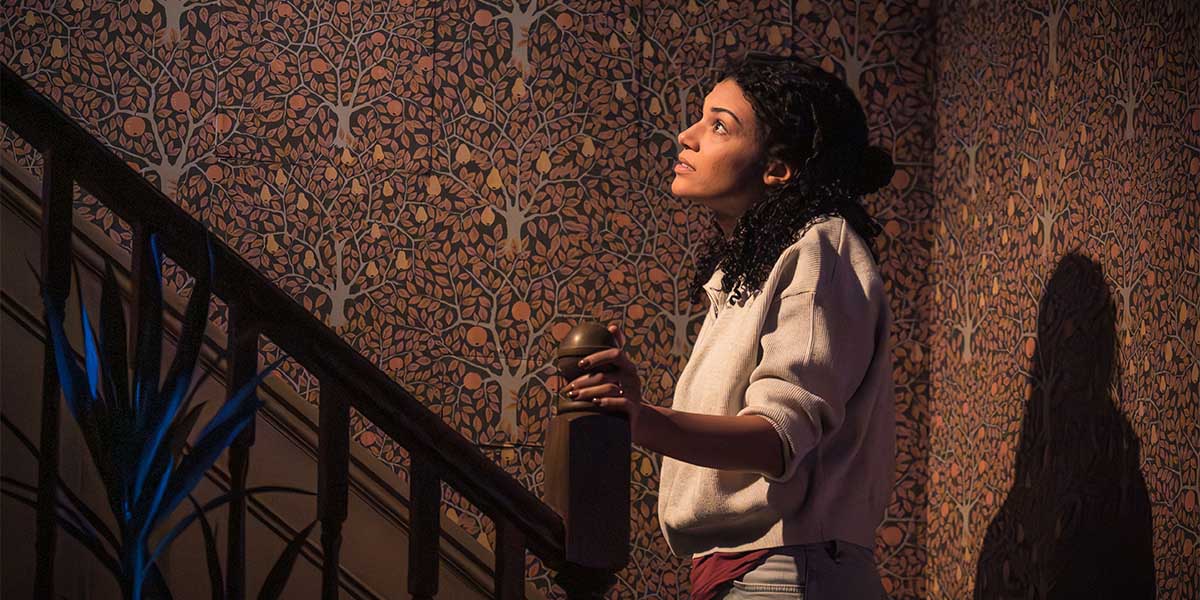 Marc Brenner stands in a dimly lit room, looking intently at a flickering light source.