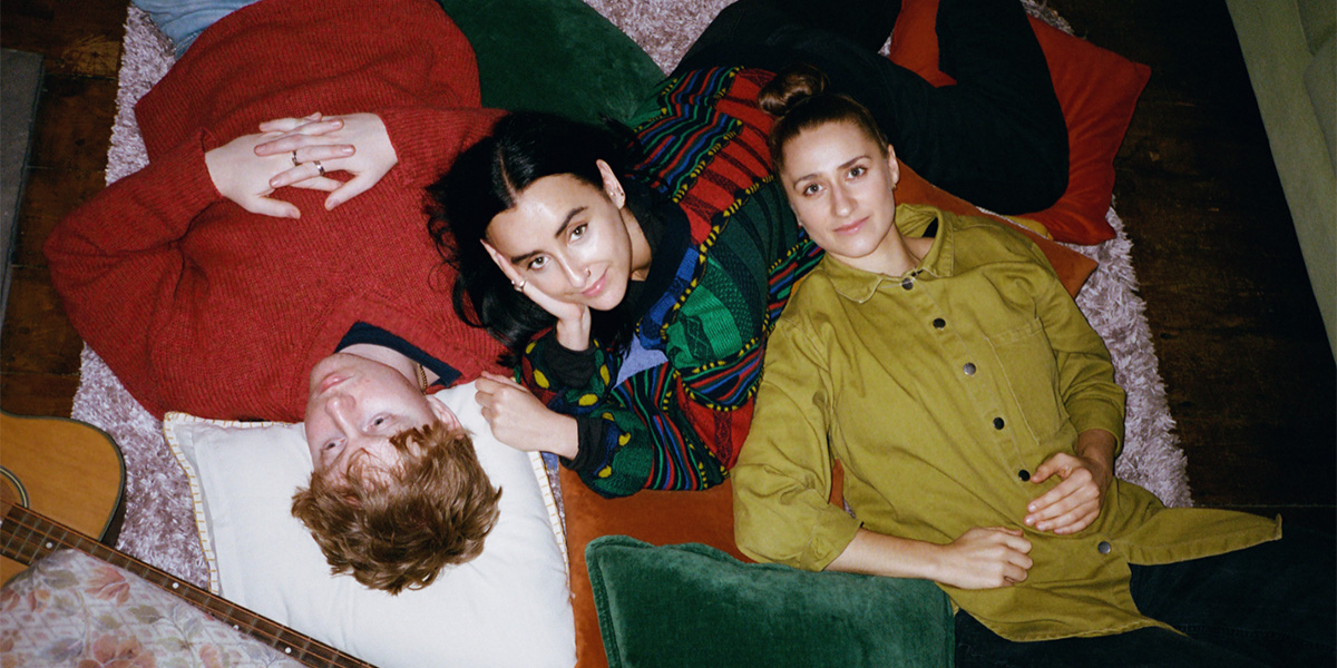 Rachel Barnes speaks at a podium, wearing a blue blouse, with a backdrop featuring the event logo.