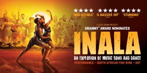 A modern office space featuring a large wooden desk, plants, and a bright, airy atmosphere.