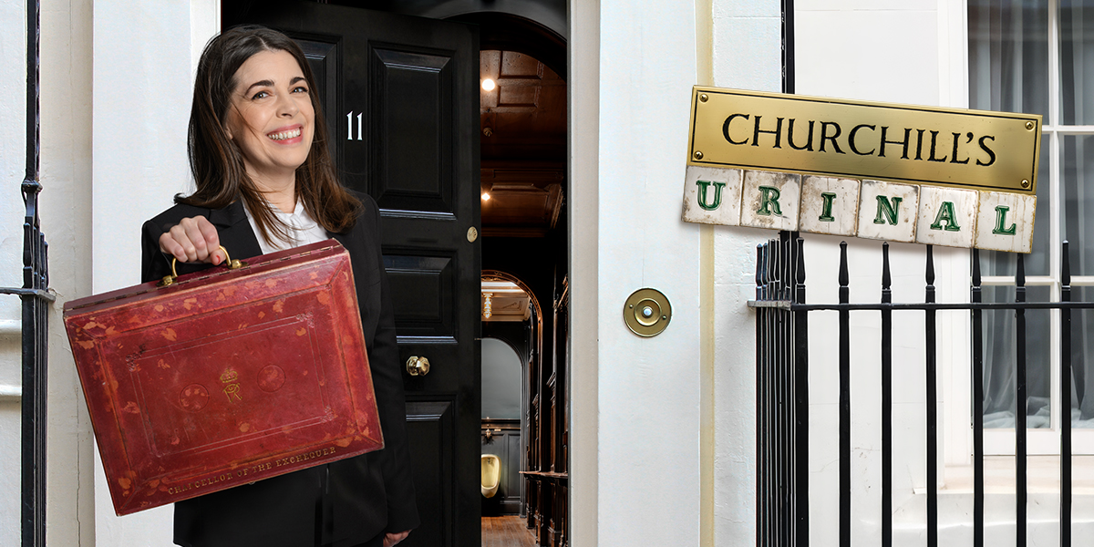 A vintage urinal displayed in a glass case, featuring ornate detailing and a dark wood background.