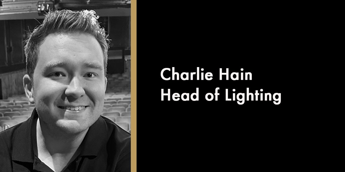 A portrait of Charlie Hain, smiling, with a blurred background, in memoriam, 2026.