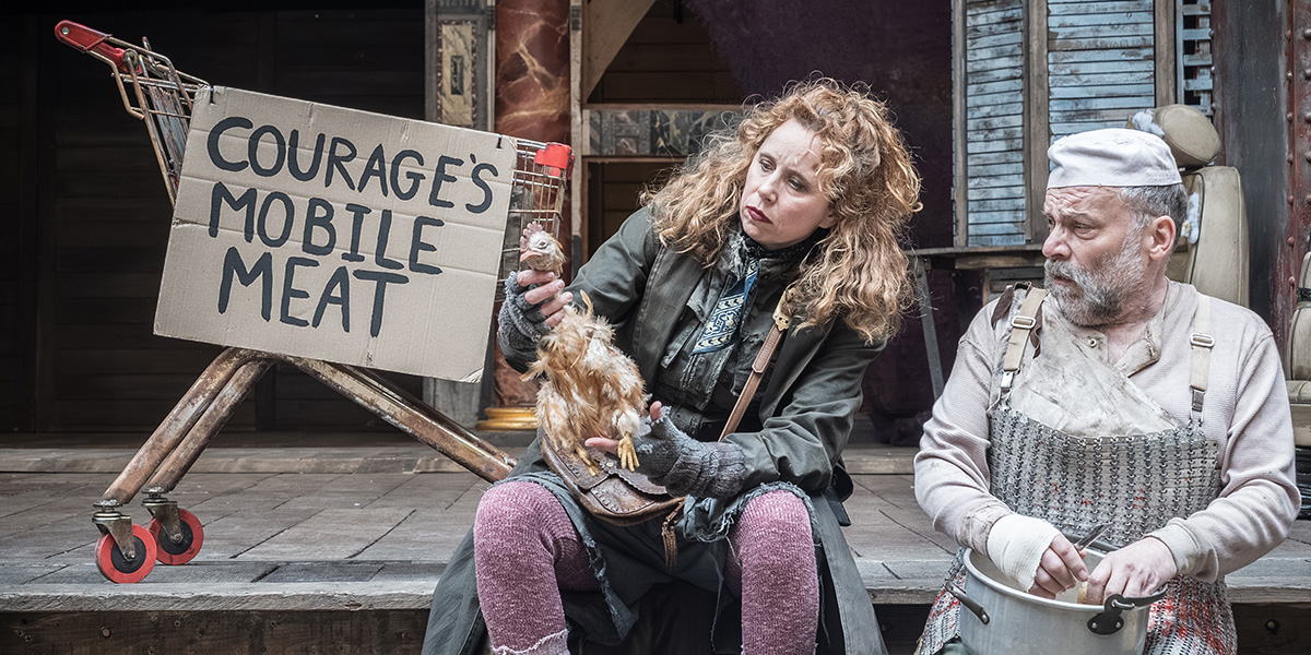 Michelle Terry as Mother Courage and Nicolas Tennant as Chef, both in period costumes, on stage at Shakespeare's Globe.