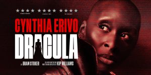 A dark, atmospheric scene featuring Cyntia Erivo as Dracula, with gothic red lighting.