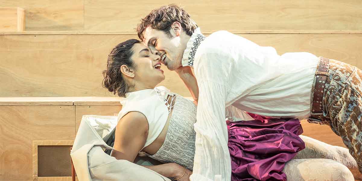 Hiftu Quasem as Hermia and Misia Butler as Lysander share an intimate moment on stage.
