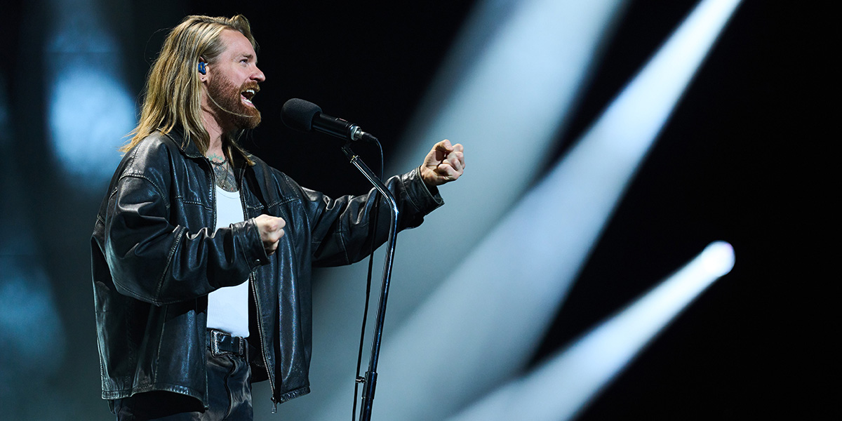 Sam Ryder performing on stage during the Big Night of Musicals 2026, wearing a black outfit and singing passionately.
