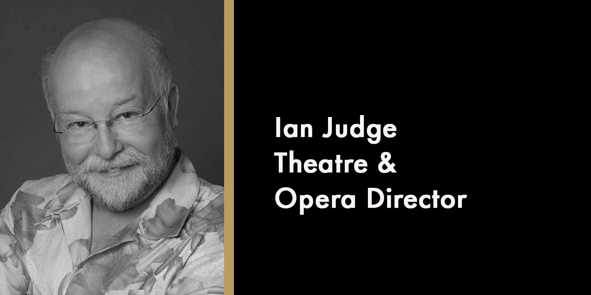 A portrait of Judge Ian, smiling, wearing a black robe, with a soft-focus background.