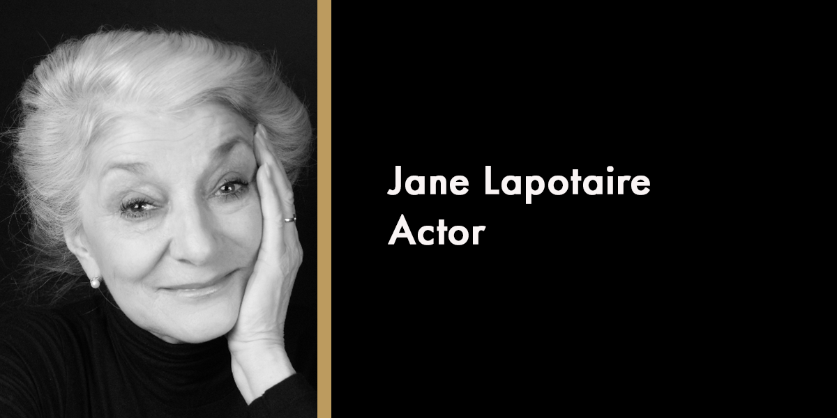 A portrait of Jane Lapotaire, smiling, with soft lighting and a blurred background, in memoriam.