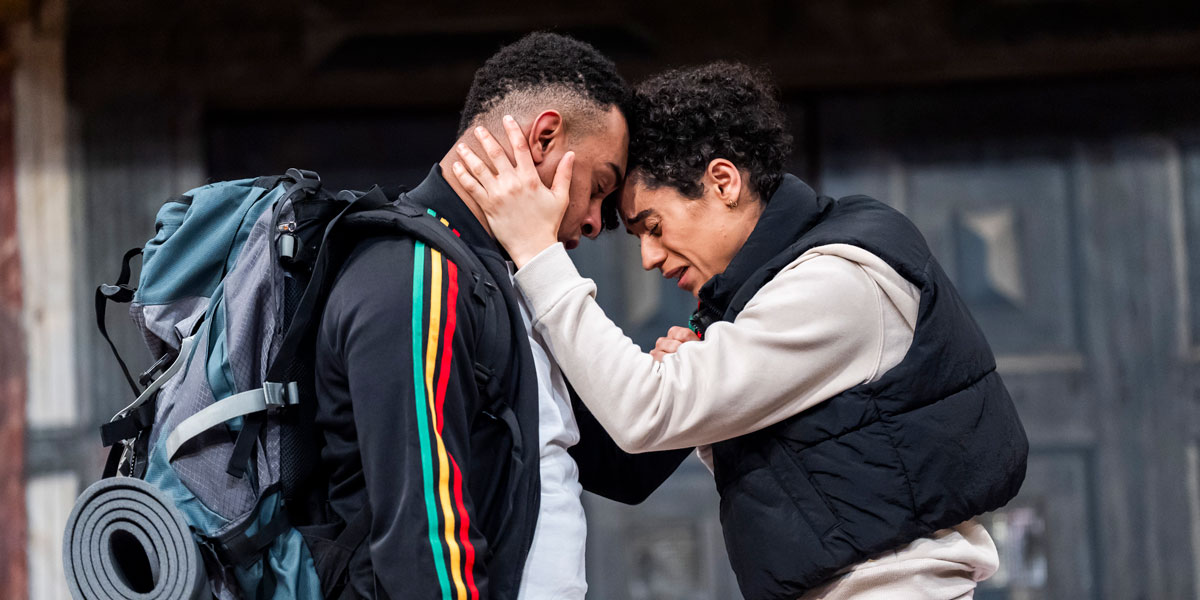 Actors performing a scene from Romeo and Juliet on stage at Shakespeare's Globe, with dramatic lighting.