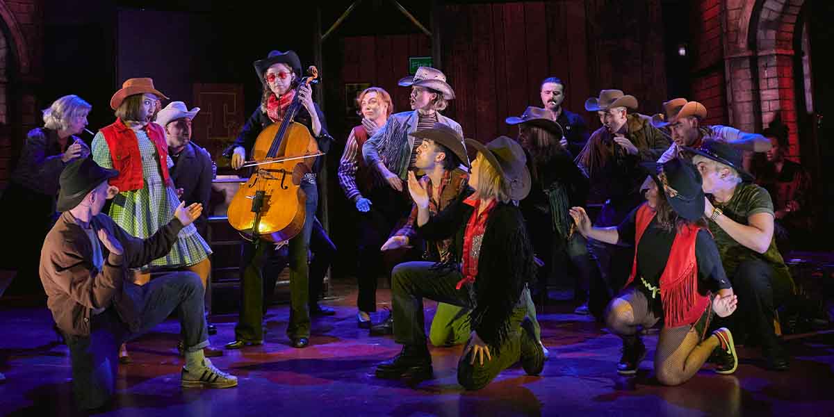 A lively musical scene with performers in cowboy attire, playing instruments and engaging in dramatic poses.