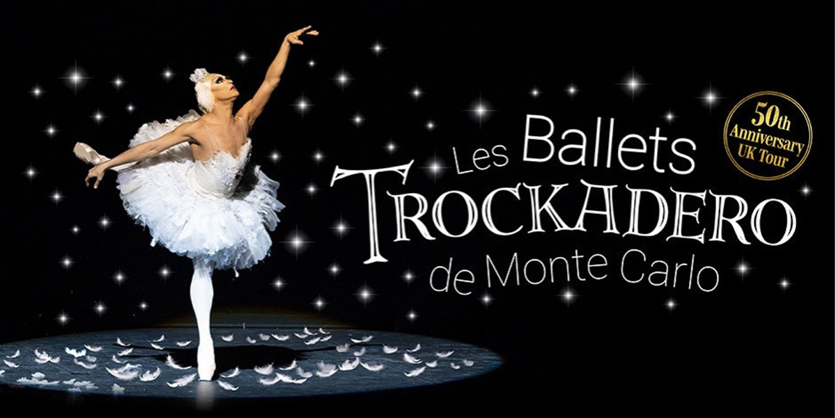 Les Ballets Trockadero De Monte Carlo dancers perform on stage, wearing vibrant tutus and ballet shoes.