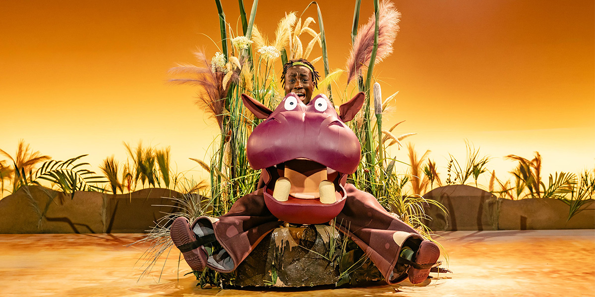 A vibrant stage scene from "The Enormous Crocodile The Musical," featuring actors in colourful costumes performing.